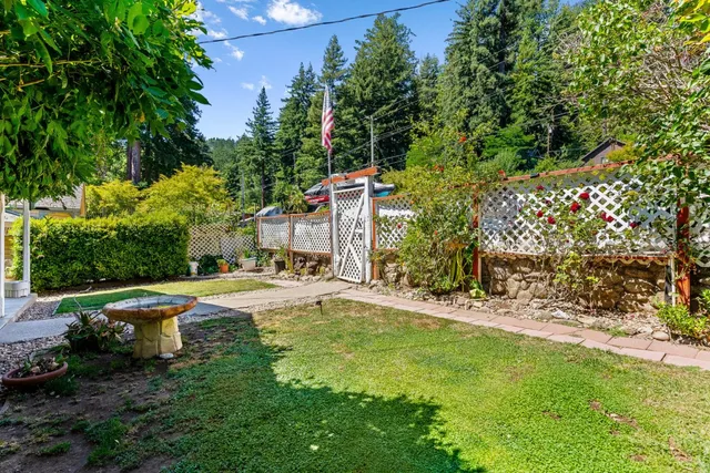a view of a yard with wooden fence