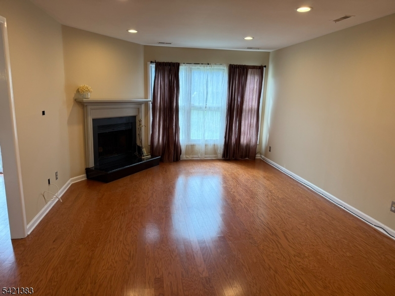 Undisclosed Address Edison, NJ 08820 - Photo 9 of 44 an empty room with wooden floor fireplace and windows