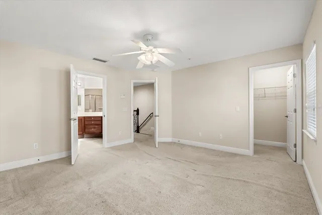 an empty room with closet and a ceiling fan