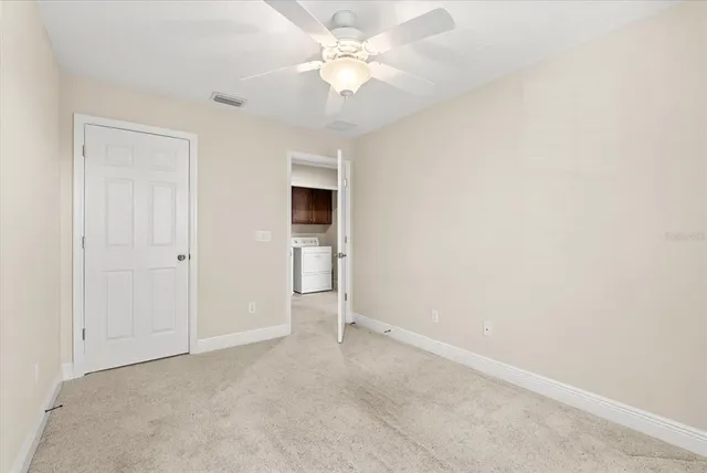 an empty room with a ceiling fan and a window