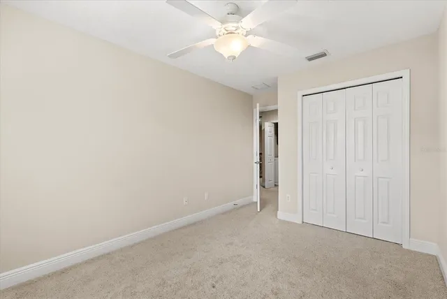 an empty room with a ceiling fan and a window