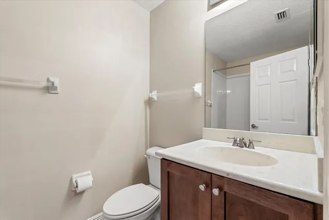 a bathroom with a granite countertop sink a toilet and a mirror