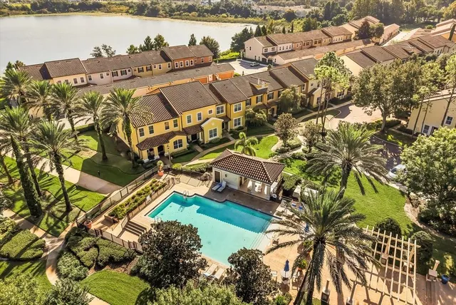an aerial view of a house with outdoor space and lake view in back