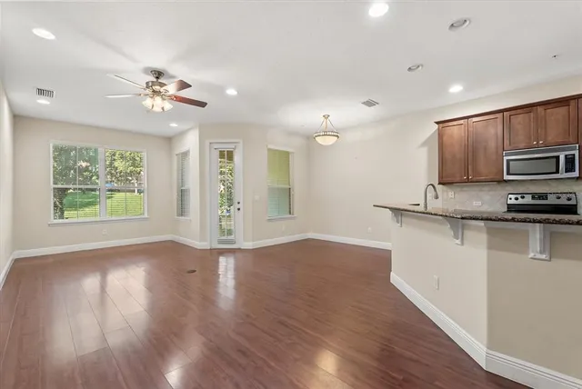 a view of kitchen with sink microwave and wooden floor