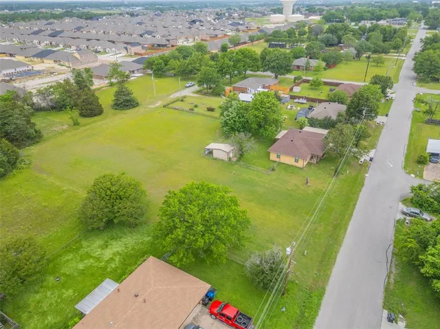 an aerial view of residential houses with outdoor space and trees all around