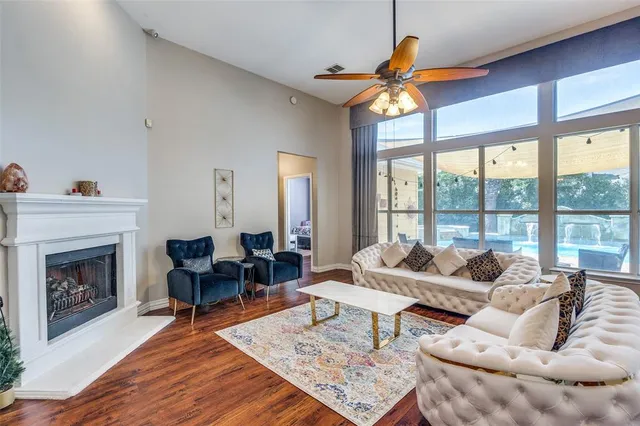 a living room with furniture a fireplace and a floor to ceiling window