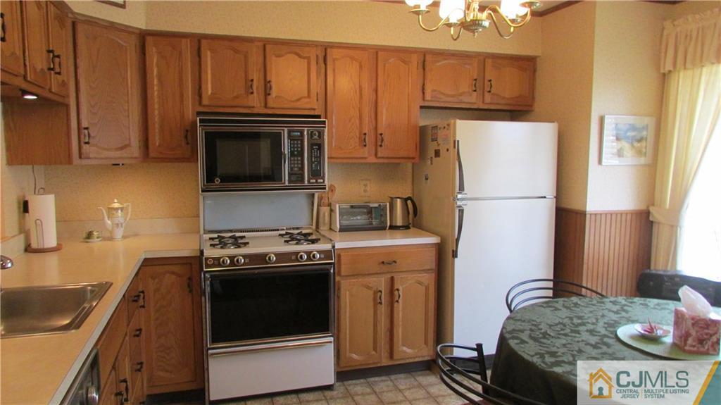 2407 Timber Oaks Road, Unit 2407 Edison, NJ 08820 - Photo 6 of 12 a kitchen with granite countertop a refrigerator stove and microwave