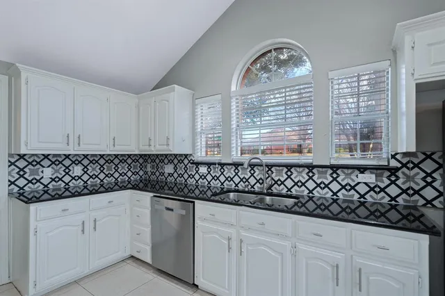 a kitchen with a sink window and cabinets