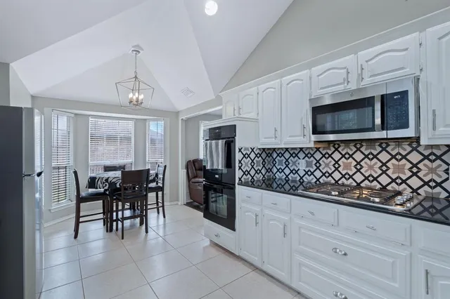 a kitchen with granite countertop cabinets and chairs