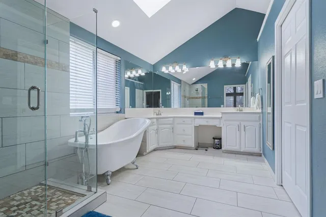 a bathroom with a double vanity sink a mirror and a bathtub
