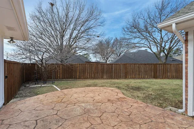 a view of backyard with wooden fence