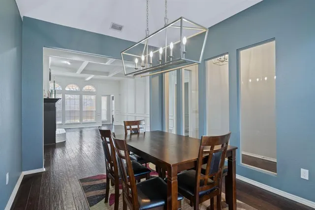 a view of a dining room and livingroom with furniture wooden floor a chandelier
