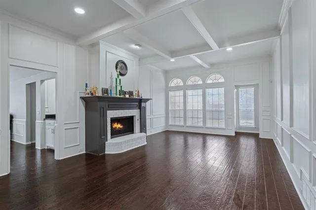 an empty room with wooden floor fireplace and windows