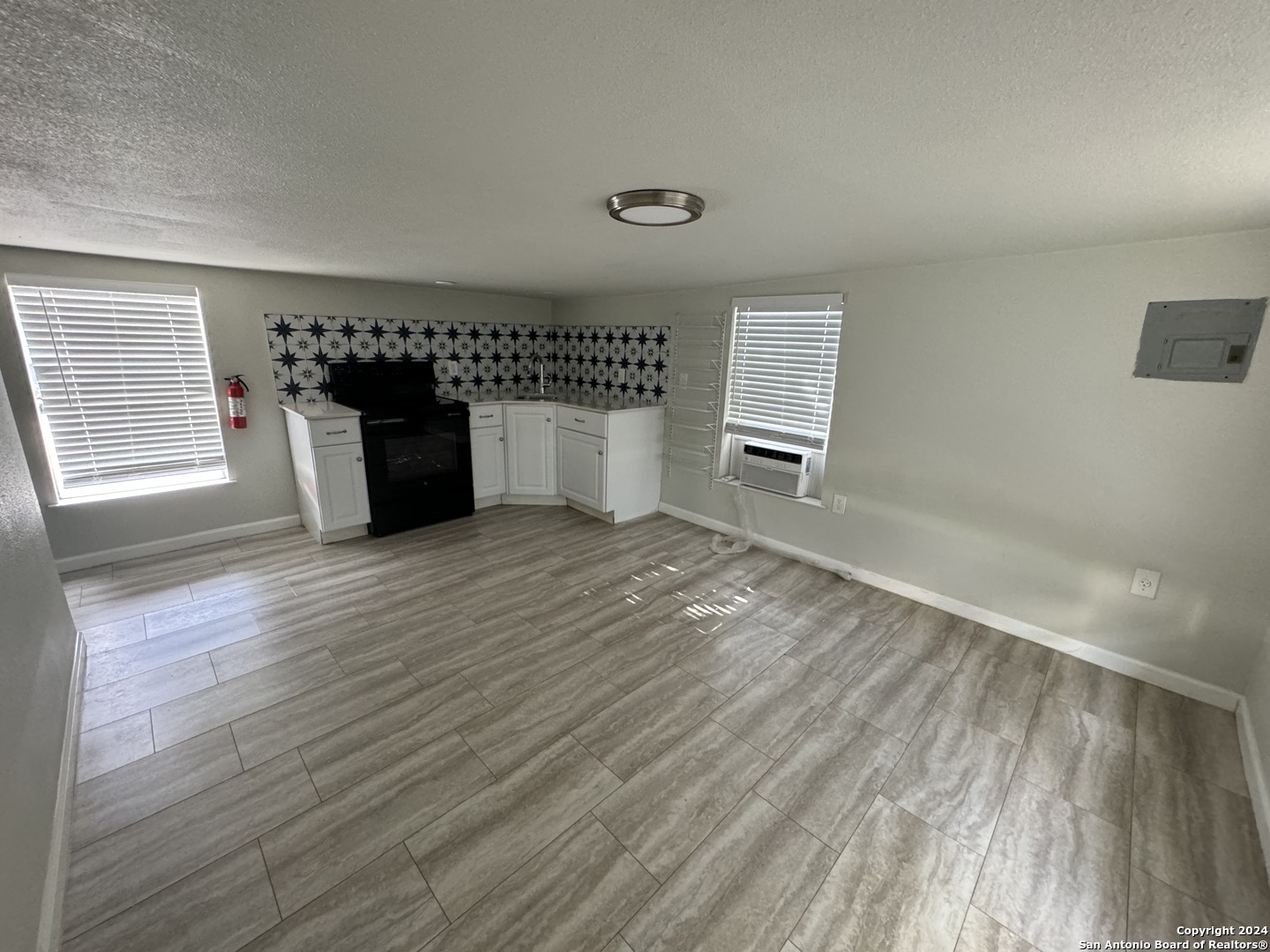 407 East Locust Street, Unit 10 San Antonio, TX 78212 - Photo 1 of 4 an empty room with wooden floor and windows