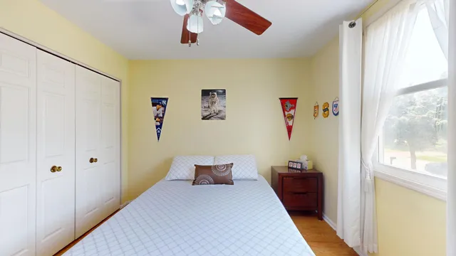 a bedroom with a bed and a large window