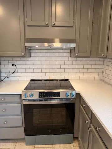 a kitchen with stove cabinets and utility