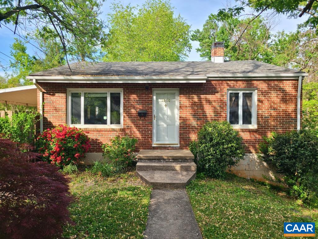 a view of a house with potted plants and a table and chairs