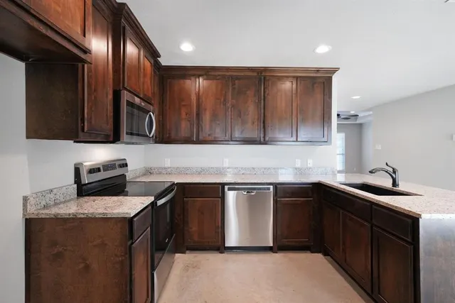 a view of a kitchen with a sink stainless steel appliances and cabinets