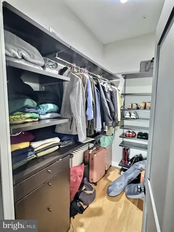 a view of walk in closet with clothes and shoes