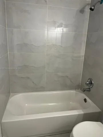 a bathroom with a toilet and bathtub