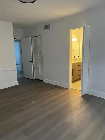 an empty room with wooden floor and a window