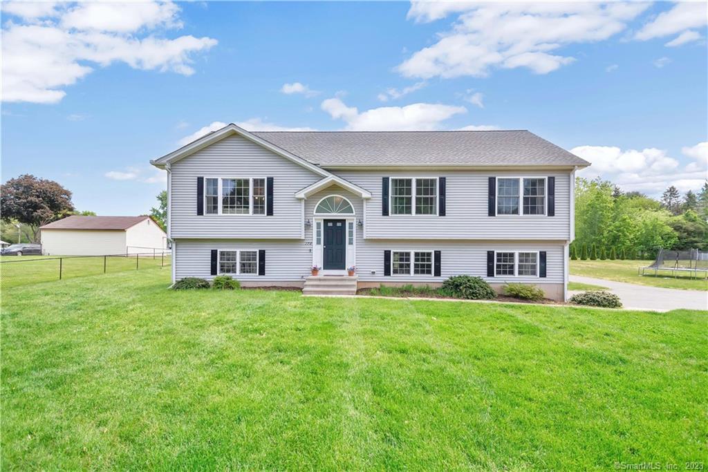 178 Graham Road South Windsor, CT 06074 - Photo 1 of 1 a house that is sitting in the grass with large trees and plants