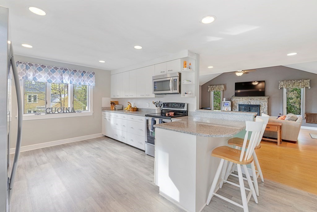 65 Charles River Street Needham, MA 02492 - Photo 6 of 21 a kitchen with a table chairs refrigerator and microwave