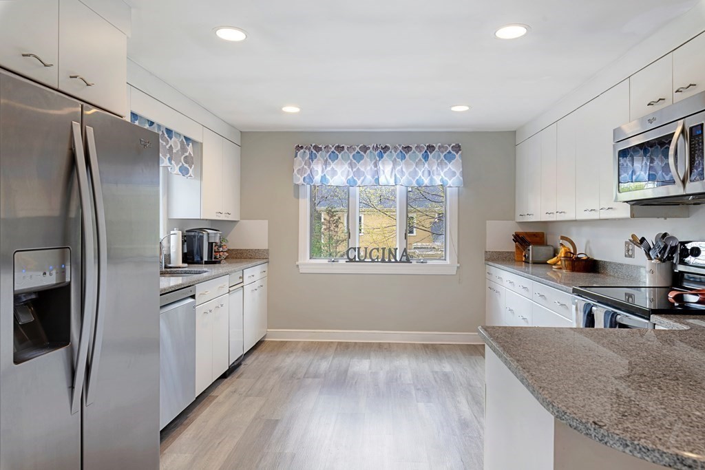 65 Charles River Street Needham, MA 02492 - Photo 7 of 21 a kitchen with stainless steel appliances granite countertop a refrigerator sink and stove