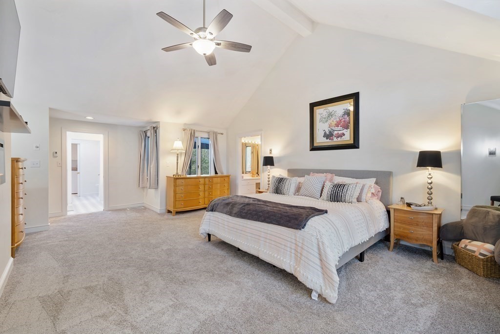 65 Charles River Street Needham, MA 02492 - Photo 10 of 21 a spacious bedroom with a bed a couch and a chandelier
