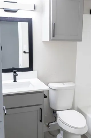 a bathroom with a toilet a sink and mirror