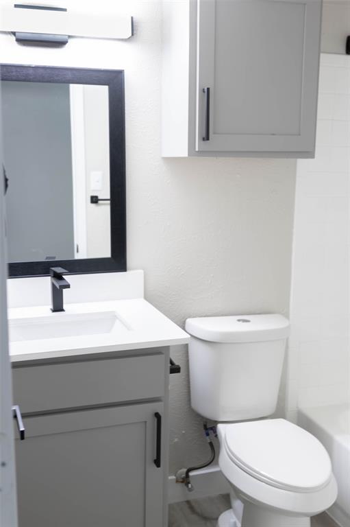 13266 Emily Road Dallas, TX 75240 - Photo 4 of 8 a bathroom with a toilet a sink and mirror