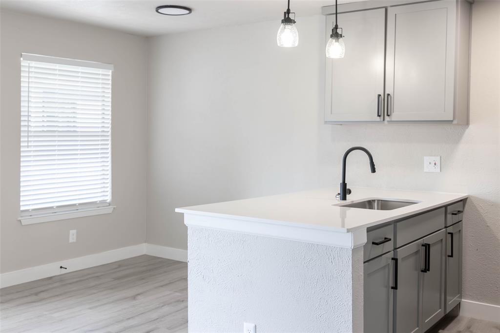 13266 Emily Road Dallas, TX 75240 - Photo 5 of 8 a kitchen with a sink cabinets and wooden floor