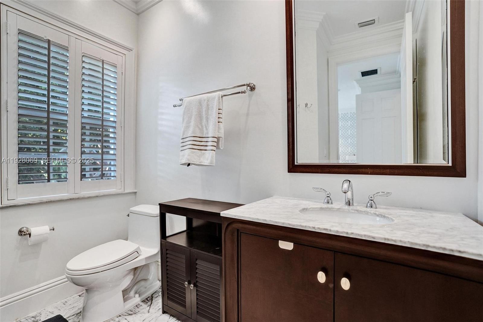 1281 Banyan Road Boca Raton, FL 33432 - Photo 53 of 69 a bathroom with a granite countertop sink a toilet and a mirror