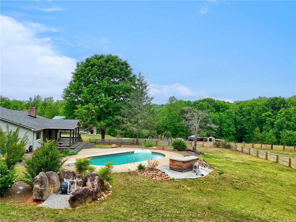 433 Latham Road Easley, SC 29640 - Photo 6 of 50 An inviting pool area awaits, surrounded by mature trees and a vast, fenced yard.