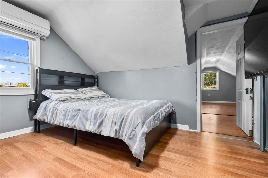 64 Vine Street Saugus, MA 01906 - Photo 24 of 42 a bedroom with a bed and wooden floor
