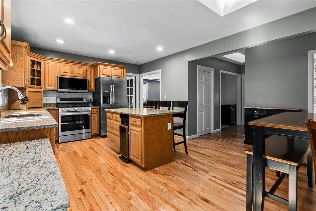 64 Vine Street Saugus, MA 01906 - Photo 4 of 42 a kitchen with stainless steel appliances kitchen island granite countertop a stove a sink and a microwave