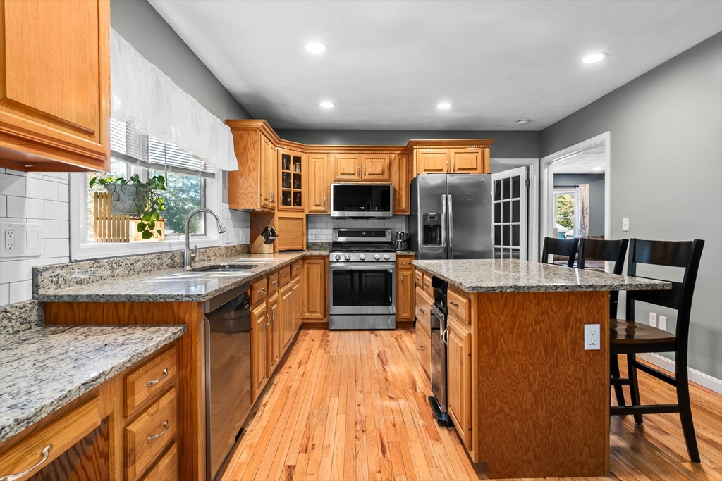 64 Vine Street Saugus, MA 01906 - Photo 5 of 42 a large kitchen with stainless steel appliances granite countertop a stove and a sink