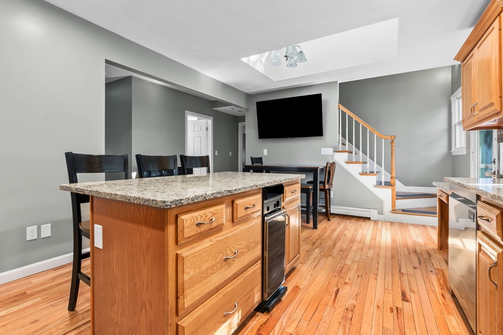 64 Vine Street Saugus, MA 01906 - Photo 6 of 42 a view of living room with granite countertop couches wooden floor and a flat screen tv
