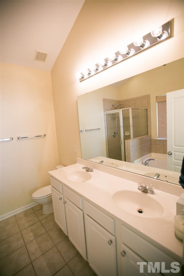 3214 Ranbir Drive Durham, NC 27713 - Photo 16 of 20 a spacious bathroom with a sink a toilet and a mirror