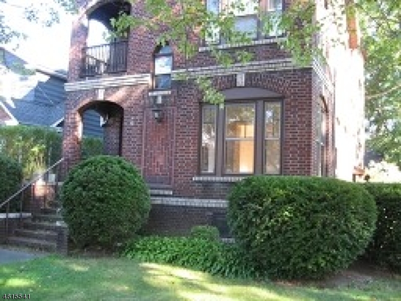 a front view of a house with plants and entryway