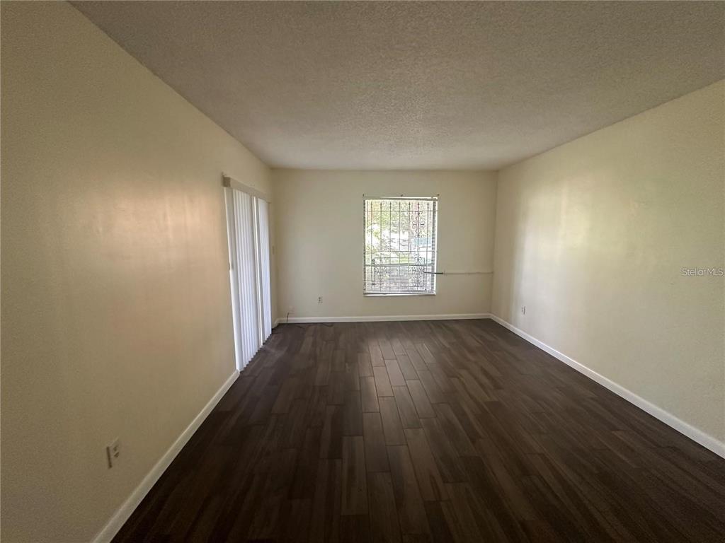 600 Cranes Way, Unit 103 Altamonte Springs, FL 32701 - Photo 9 of 17 an empty room with wooden floor and windows
