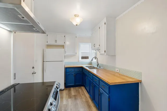 a kitchen with granite countertop a sink stove and refrigerator