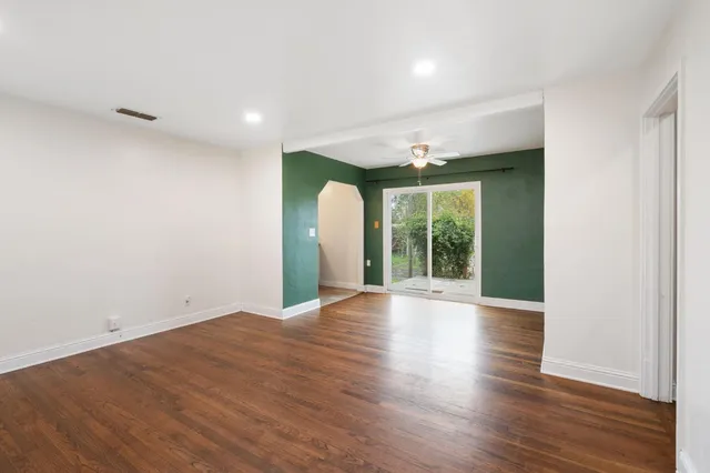 an empty room with wooden floor and a window