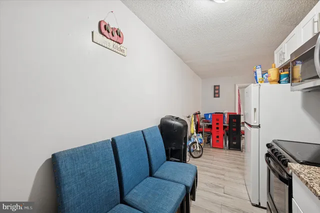 a living room with furniture a refrigerator and a couch