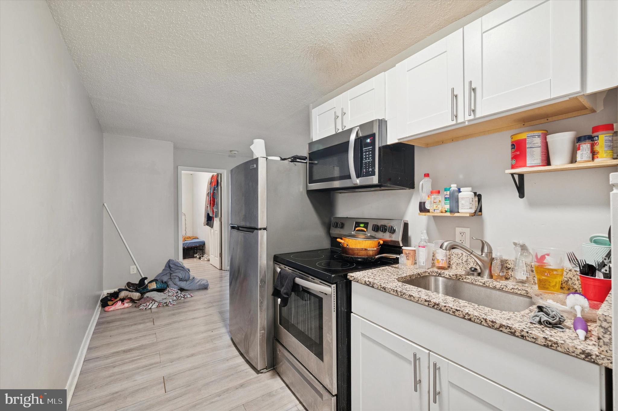 425 Main Street Darby, PA 19023 - Photo 16 of 18 a kitchen with a sink dishwasher a stove and a wooden floor