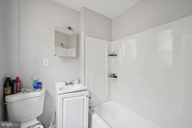 a bathroom with a sink toilet vanity and tub