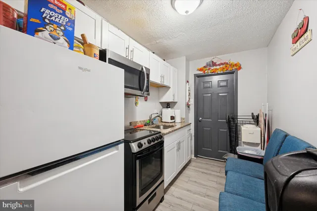 a kitchen with stainless steel appliances a sink a stove a refrigerator and cabinets