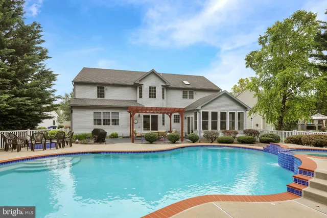 a view of a house with swimming pool and sitting area