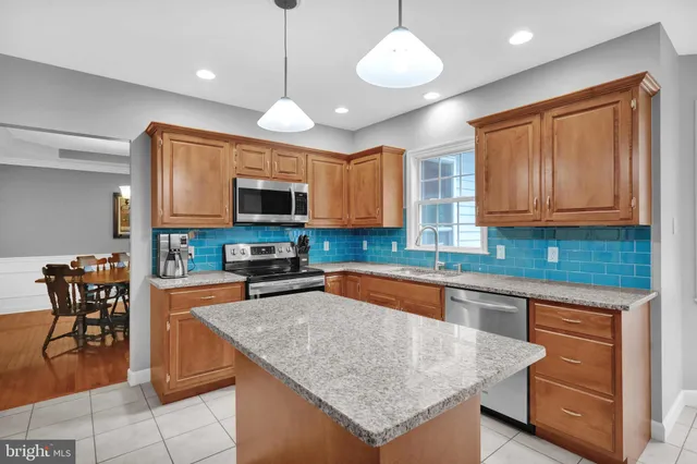 a bathroom with a granite countertop sink and a toilet