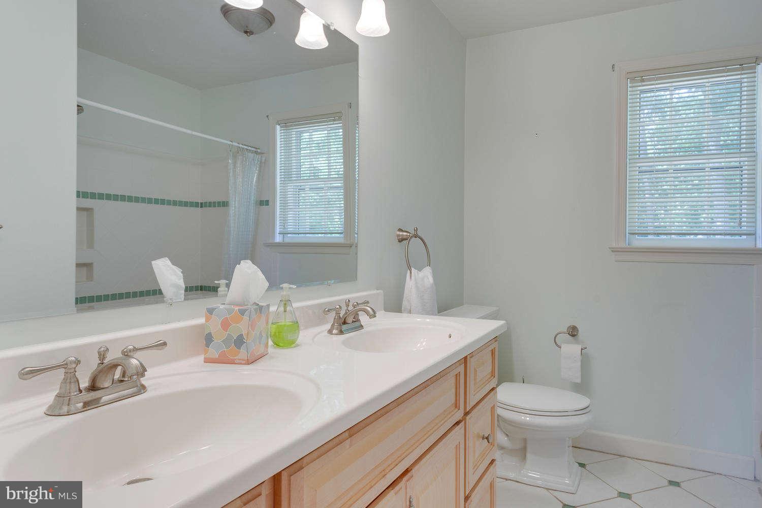 1524 Laurel Hill Road Vienna, VA 22182 - Photo 17 of 29 a bathroom with a granite countertop toilet sink and mirror